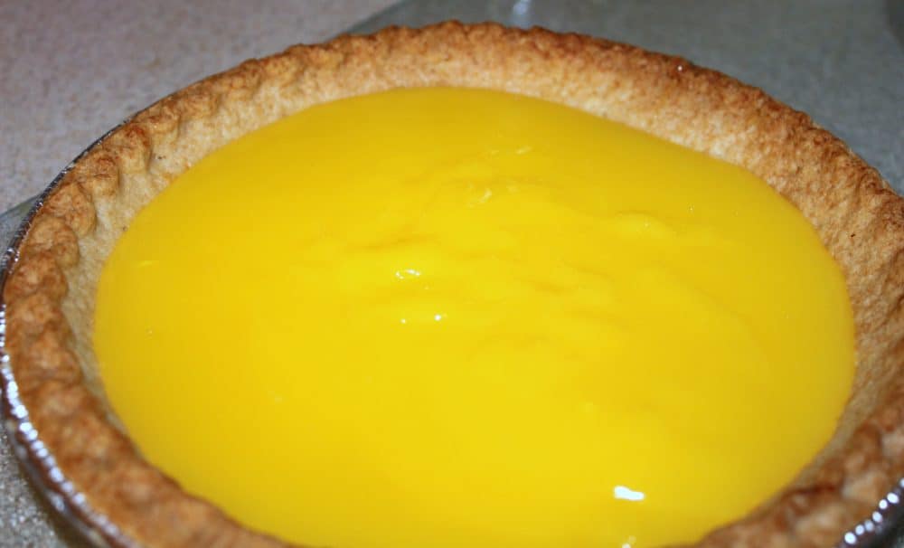 filling a pie crust with lemon pudding