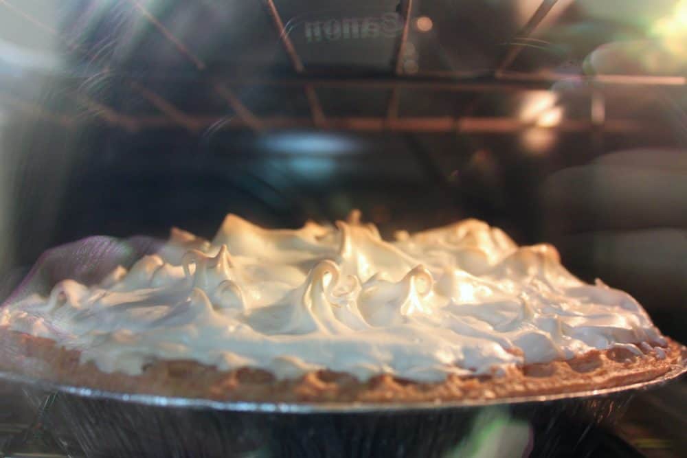 a lemon meringue pie baking in the oven