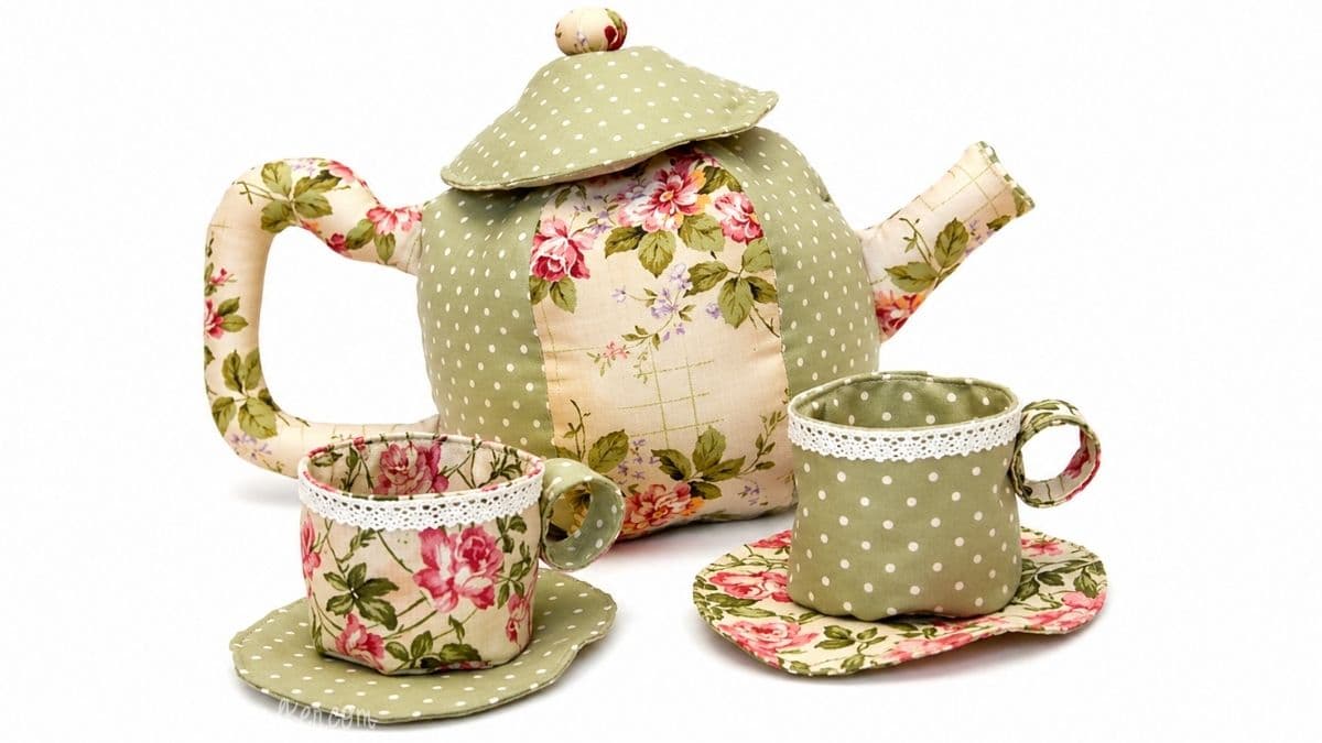 Fabric teapot and matching tea cups made from floral and polka dot fabric, displayed with coordinating fabric coasters on a white background.