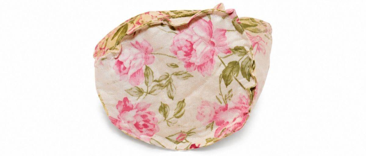 Bottom view of a floral fabric teacup showing the sewn circular base attached to the cup body as part of a handmade soft tea set.