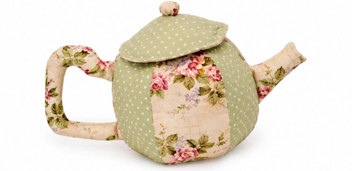 Finished fabric teapot with matching lid, floral panels, and green polka dot accents, sewn as part of a soft toy tea set.