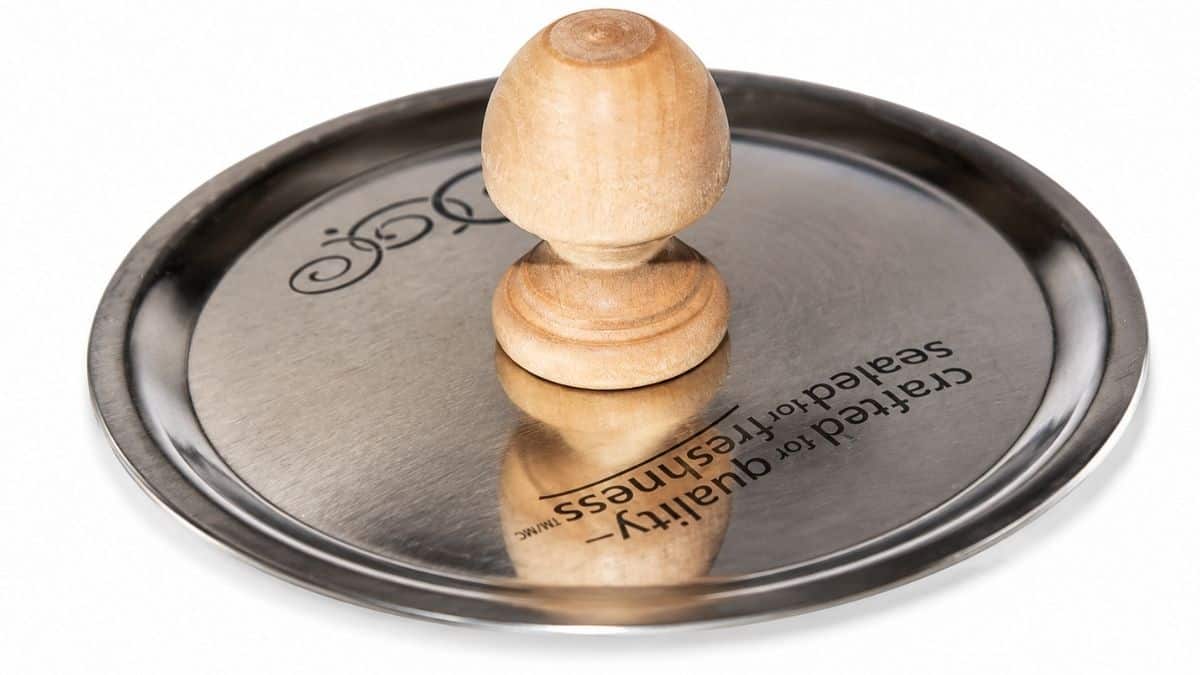 Metalen deksel van een stenen pot met een houten knop in het midden bovenaan, waarop het deksel gemonteerd is voor een doe-het-zelf-snoeppot of een decoratief opbergproject.