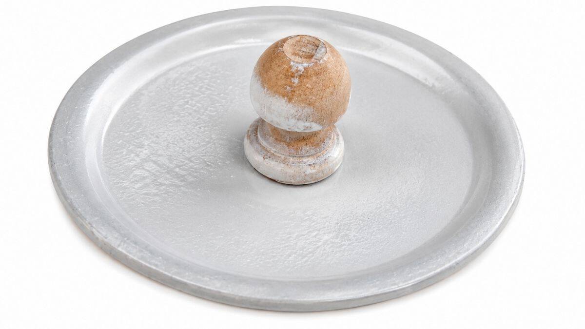 Geschilderd deksel van een stenen pot met een houten knop eraan, bedekt met witte verf en klaar om te drogen voor een doe-het-zelf-decoratief snoeppotproject.