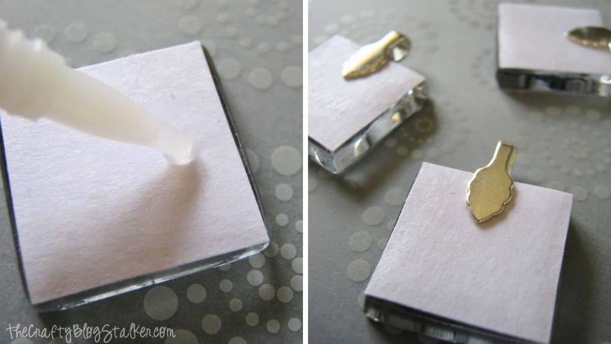Applying glue to the back of a glass tile pendant and attaching metal bails to create necklace charms.