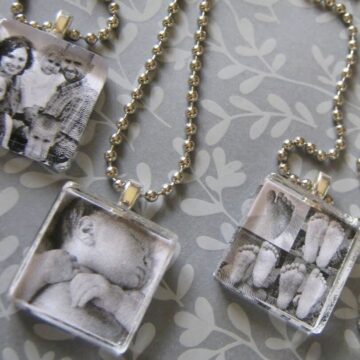 Three handmade glass tile photo pendant necklaces with ball chains, featuring black and white images of a family, a baby, and baby feet.