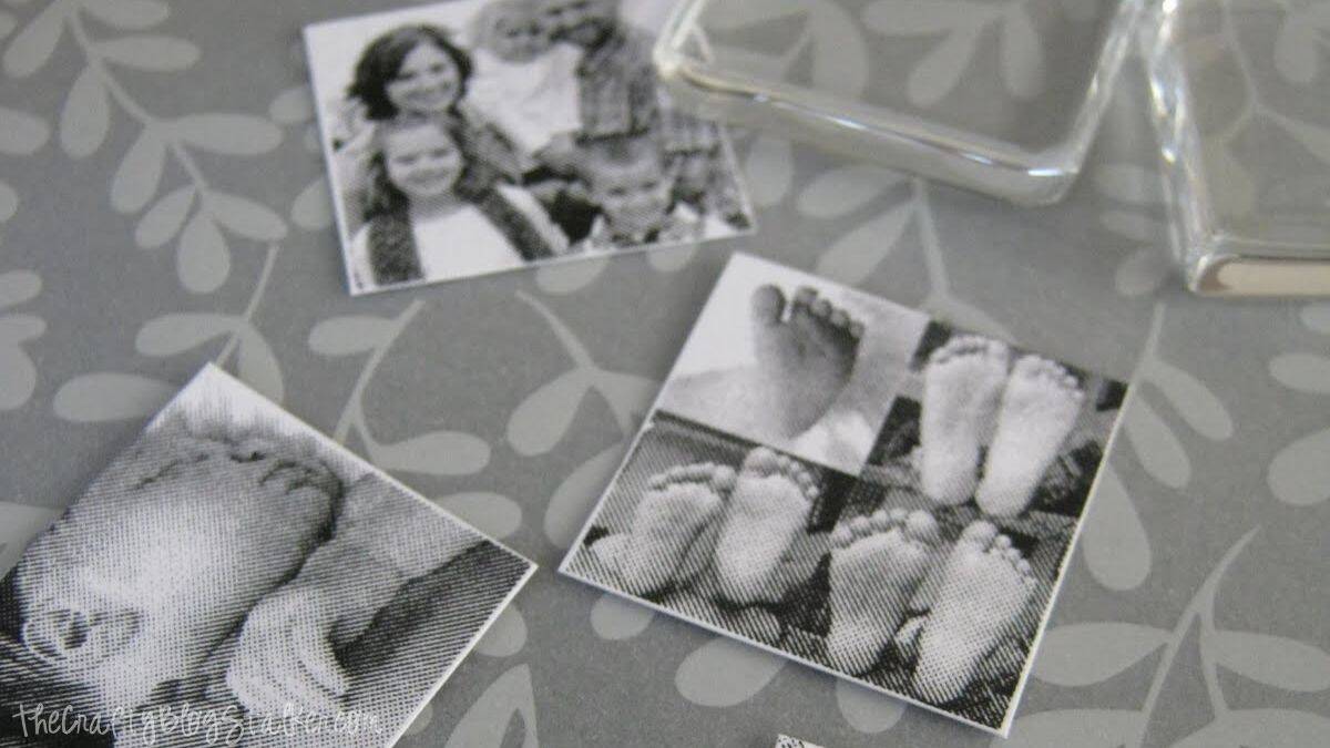 Black and white printed photos of family and baby feet cut into squares, prepared for making DIY picture pendant necklaces with glass tiles.