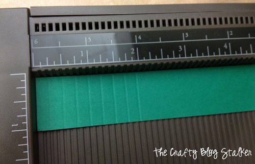 a strip of green paper with score marks to make a lollie