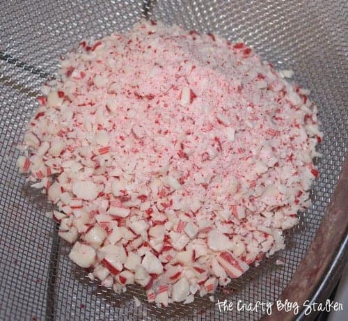 Straining crushed candy cane pieces.