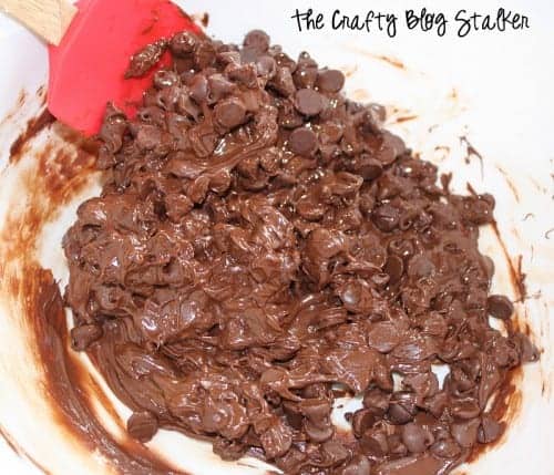 Stirring melting chocolate chips with a rubber spatula.