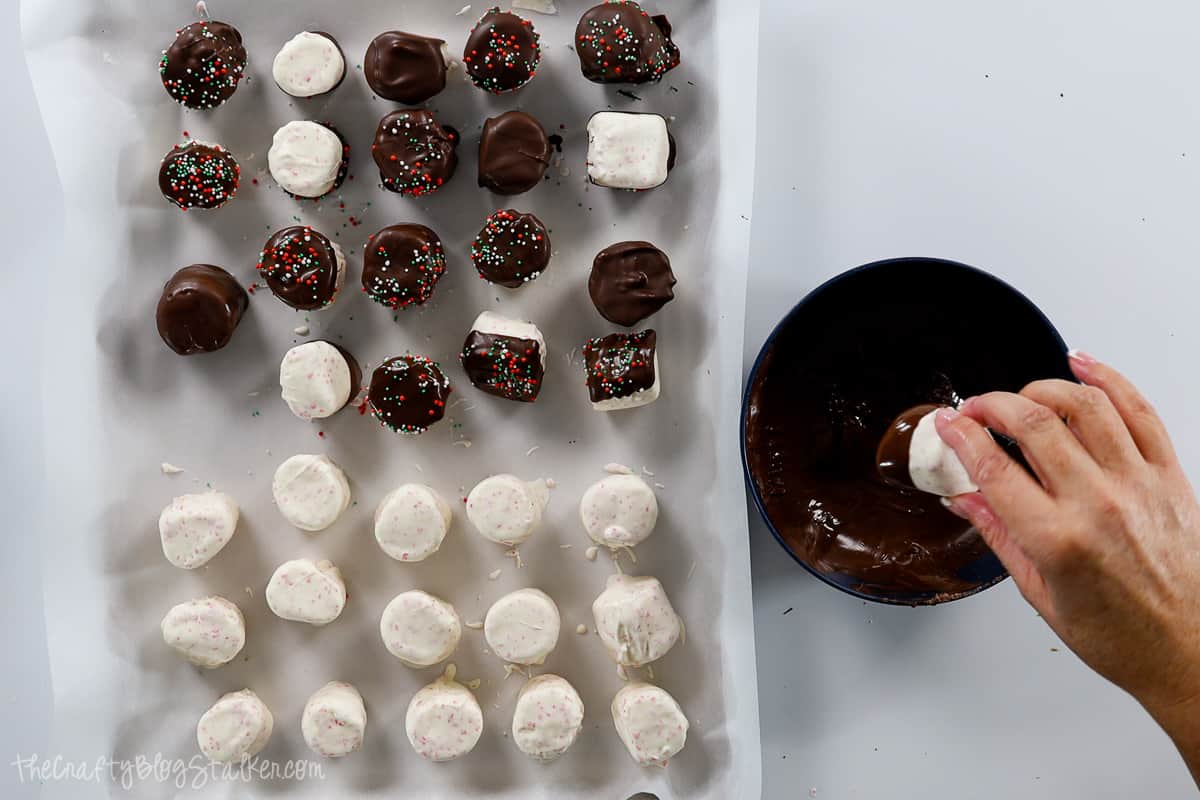 Dipping the marshmallows into dark chocolate.