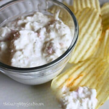 Small bowl of clam dip with a side of potato chips.