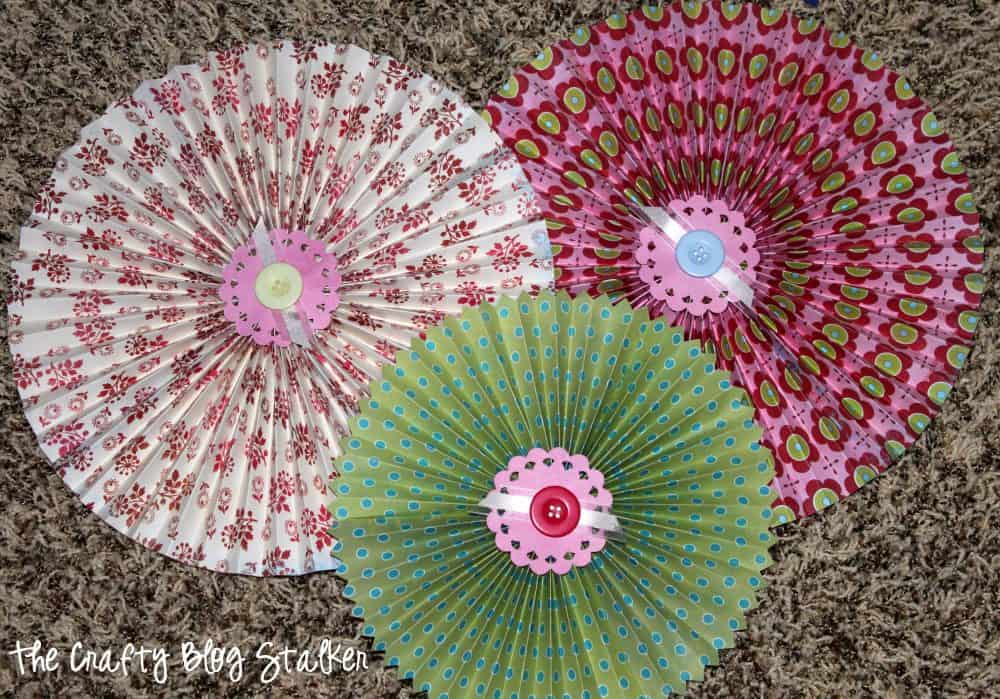 3 DIY paper rosettes of different sizes, made out of patterned paper.