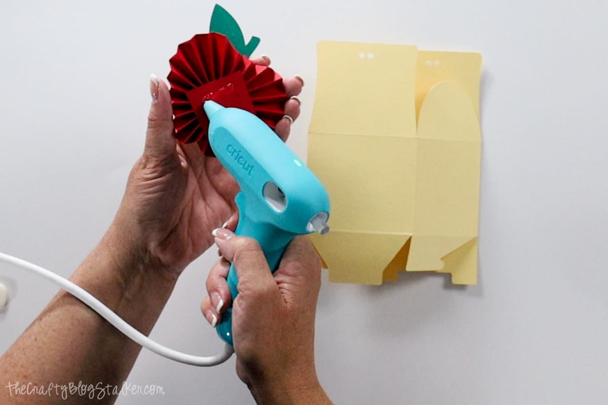 Applying hot glue to the back of the apple rosette.