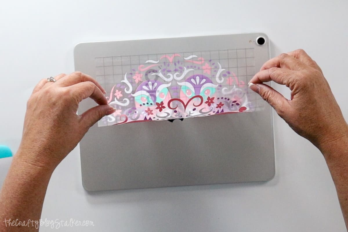 Rolling the vinyl design onto the back of an iPad.
