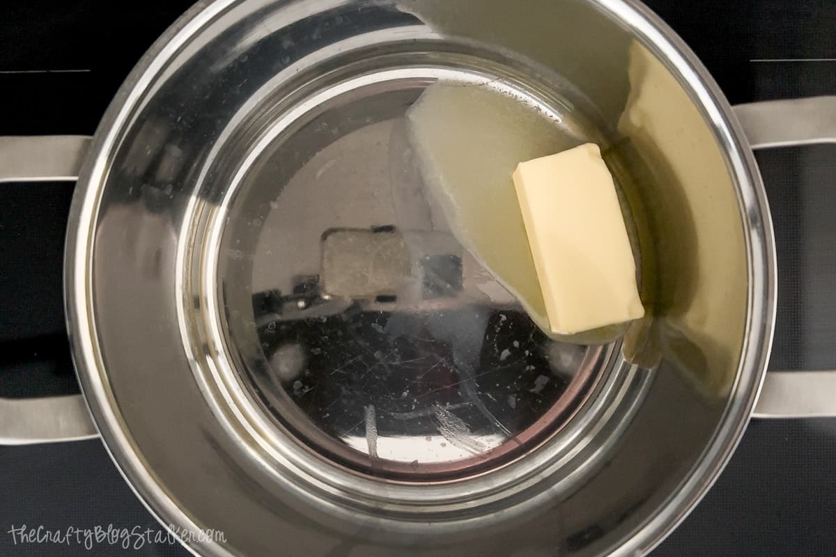 Butter melting in a pot on the stove.