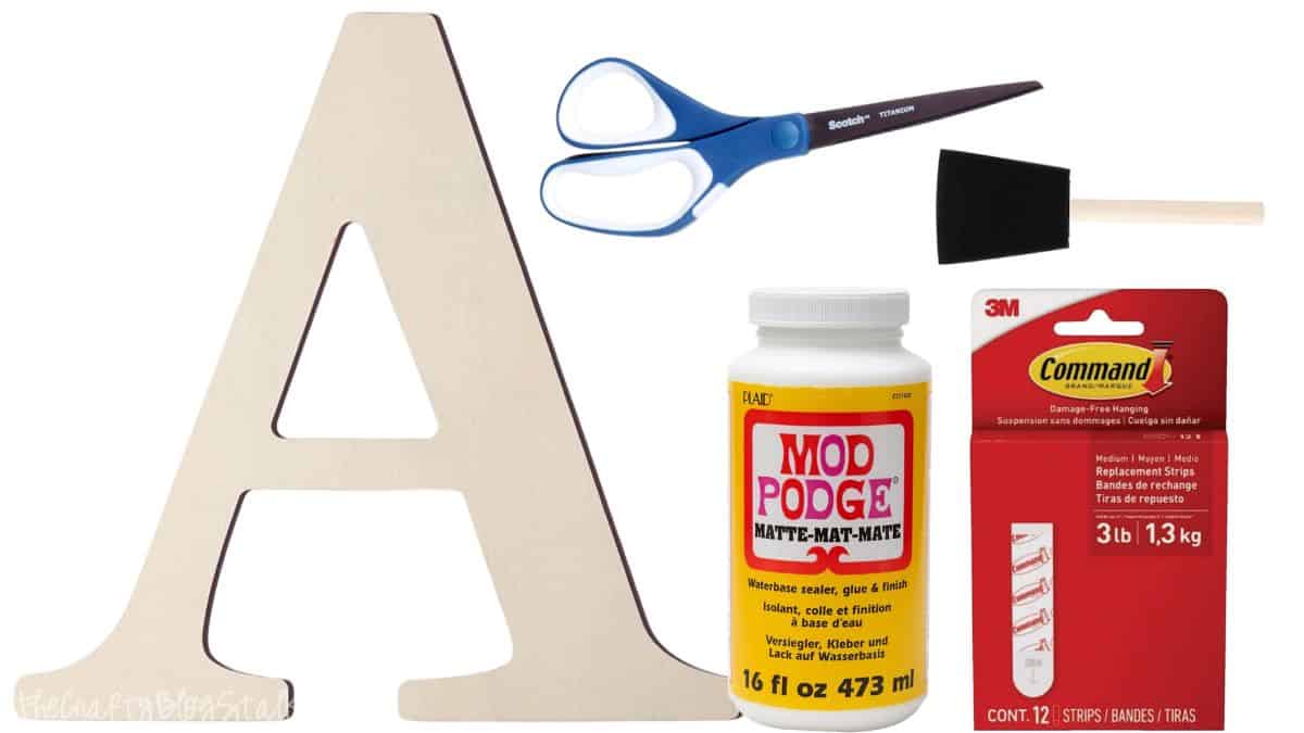 Wood letter A, foam brush, Mod Podge jar, and Command hanging strips arranged on a white background.