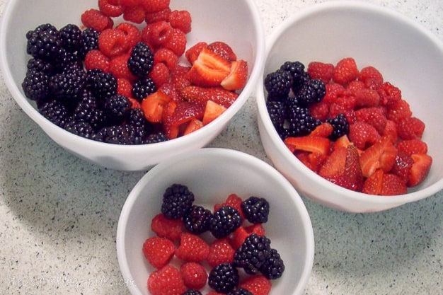 strawberries, raspberries, and blueberries divided into 3 bowls