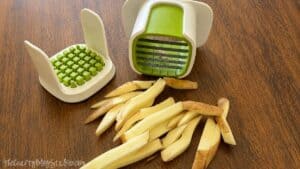 French fry cutter with sliced russet potatoes, showing thick potato wedges ready to be baked or fried for homemade fries.