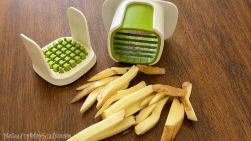 French fry cutter with sliced russet potatoes, showing thick potato wedges ready to be baked or fried for homemade fries.