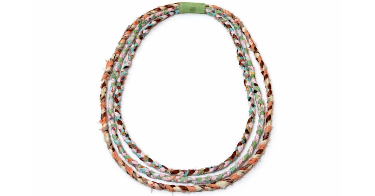Three-strand braided fabric necklace in colorful prints, joined neatly with a green fabric-wrapped closure, showcasing a handmade and boho-chic accessory.