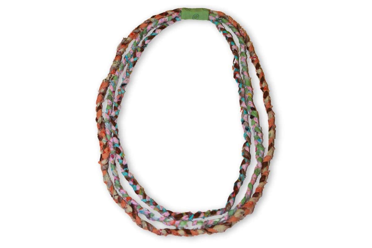 Three-strand braided fabric necklace in colorful prints, joined neatly with a green fabric-wrapped closure, showcasing a handmade and boho-chic accessory.