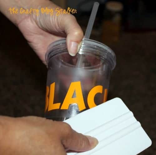 image of applying orange vinyl to a plastic cup with straw to make a new school year teacher gift