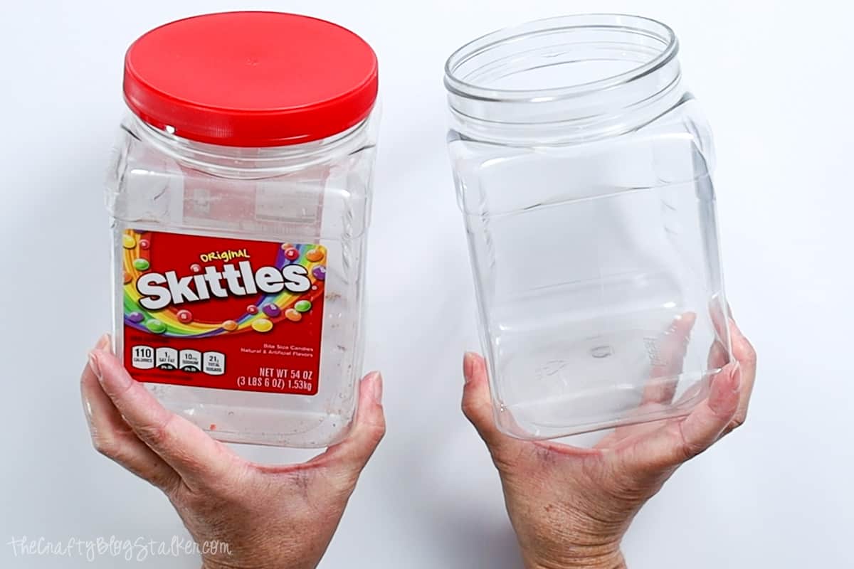 Two plastic skittles containers, one with the label removed.