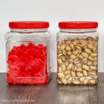 Two Skittles containers with the labels removed and filled with candy and nuts.