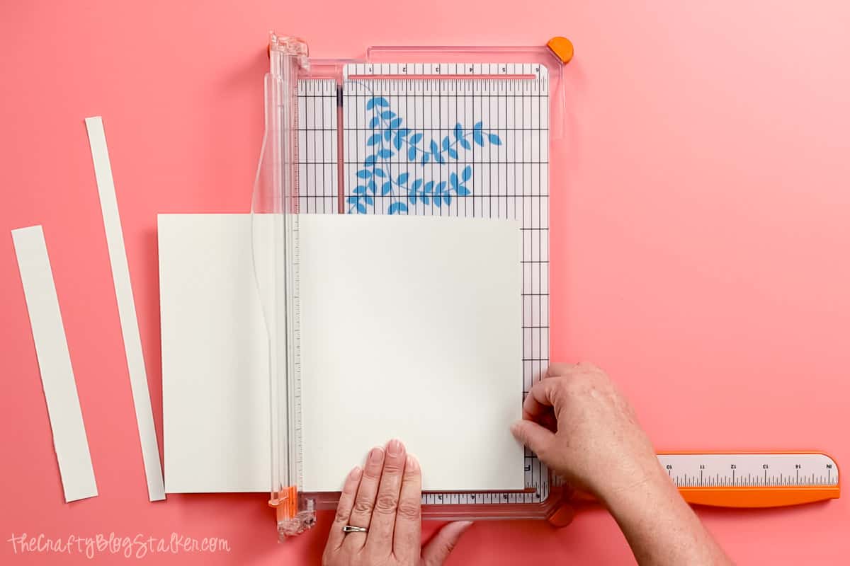 Cutting watercolor paper into foldable cards with a paper trimmer.