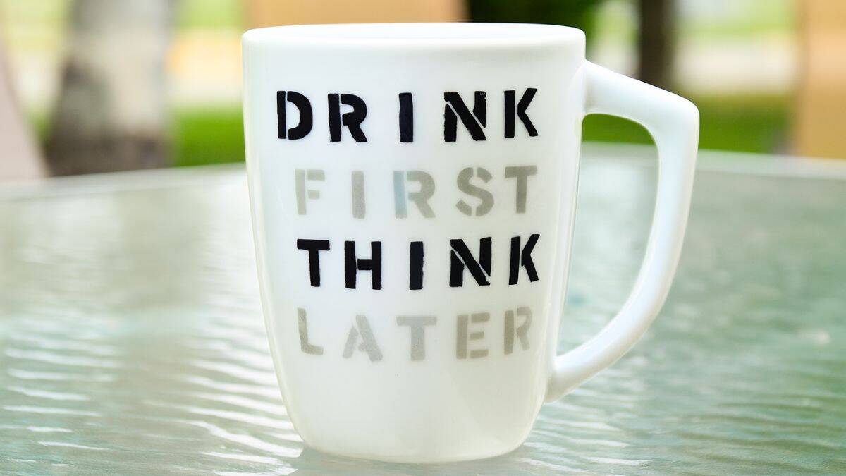 White ceramic mug on a glass table with the phrase 