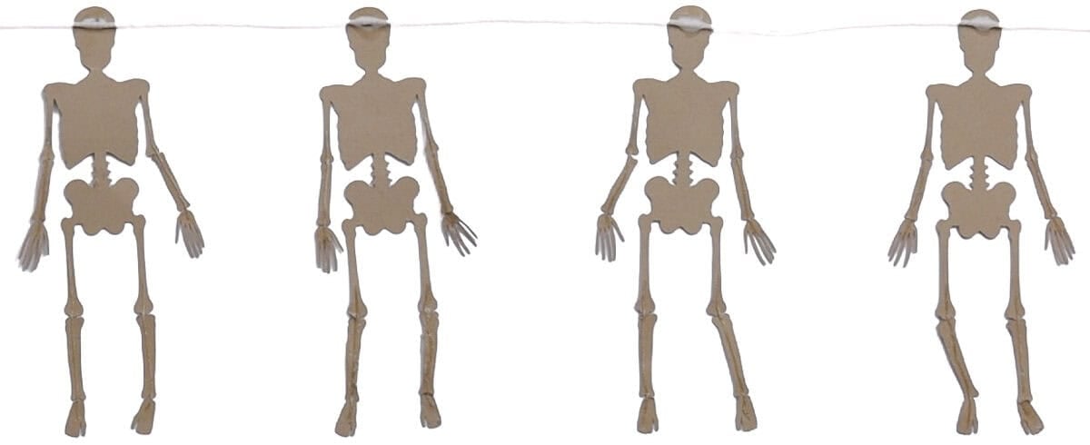 Four kraft paper skeletons attached to a string and laid face down while the glue dries for a Halloween skeleton banner.