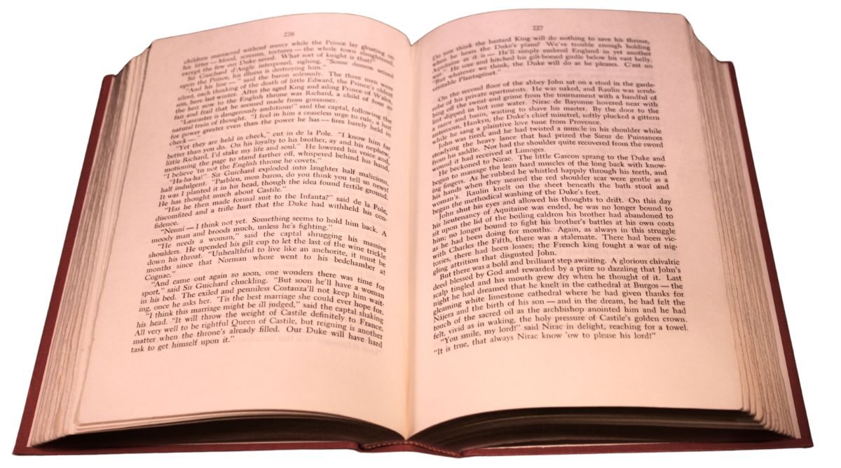 An open vintage book with aged, slightly uneven pages, showing text on both sides and a visible center crease in the binding.