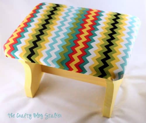 Yellow footrest with a chevron fabric top.