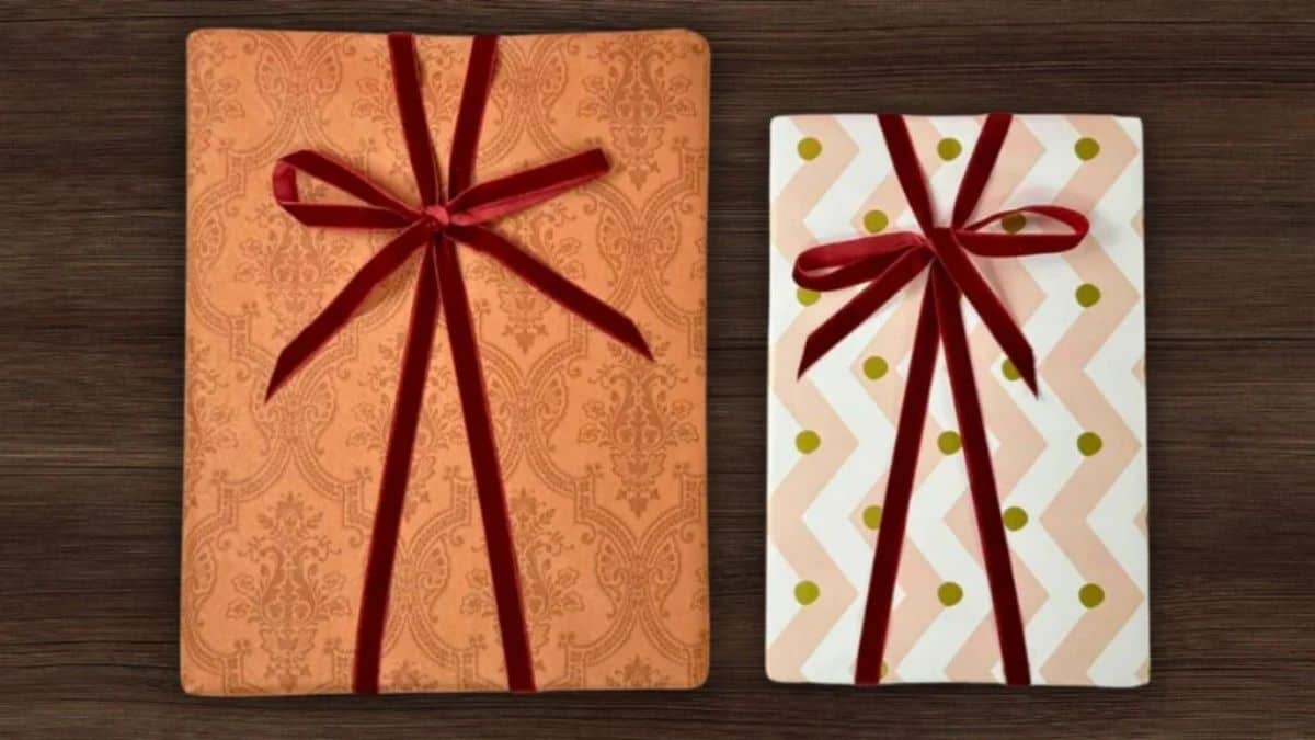 Two wrapped gifts with patterned paper and red ribbon tied into neat bows using a simple ribbon tying technique.