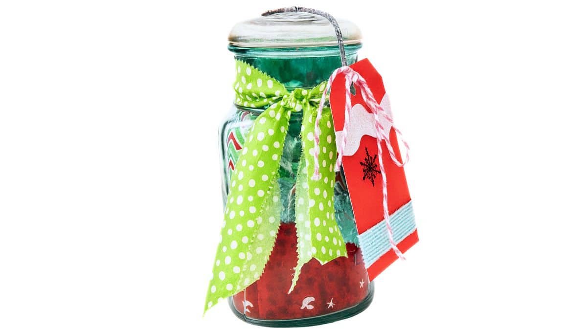 Vintage mason jar decorated with a green polka dot fabric bow and a handmade red gift tag, used as a festive container for holding a gift card.