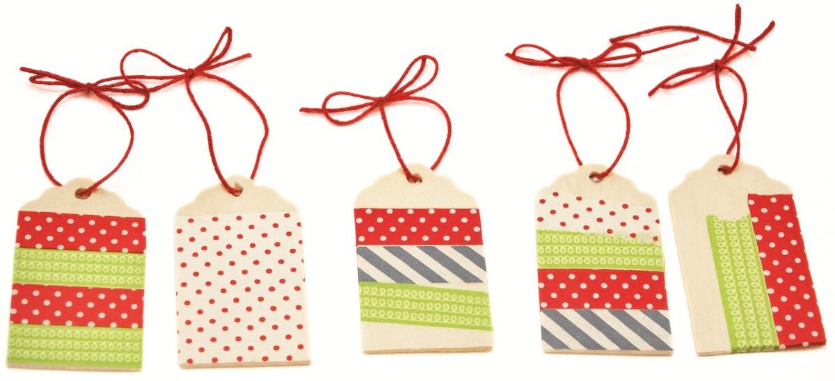 Washi Tape Ornaments made with wooden tags Five handmade wooden tags decorated with washi tape patterns and tied with red string, arranged in a row.