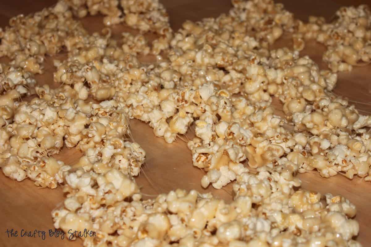 Buttery caramel popcorn cooling on wax paper.
