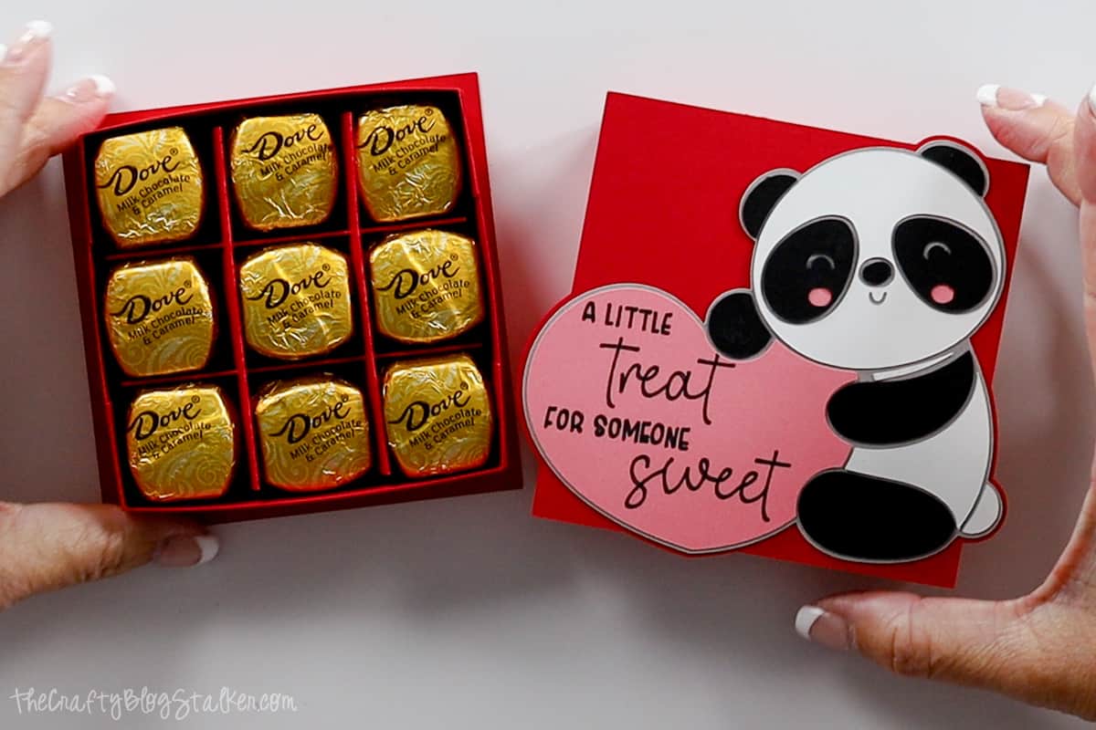 Hands holding a paper box with a panda on the front holding a heart that says "A little treat for someone sweet." The box is filled with chocolates.