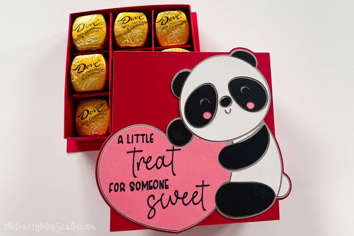 Paper box with a panda on the front holding a heart that says "A little treat for someone sweet." The box is filled with chocolates.