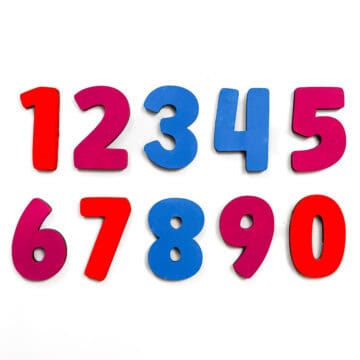 Set of colorful wooden number magnets 0–9 in red, pink, and blue, arranged on a white background for educational or crafting use.