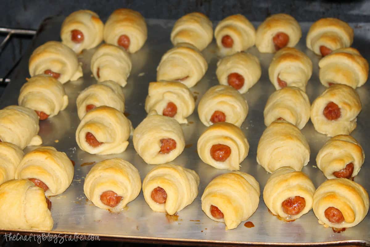 Mini pigs in a blanket on a baking sheet after pulling them out of the oven.