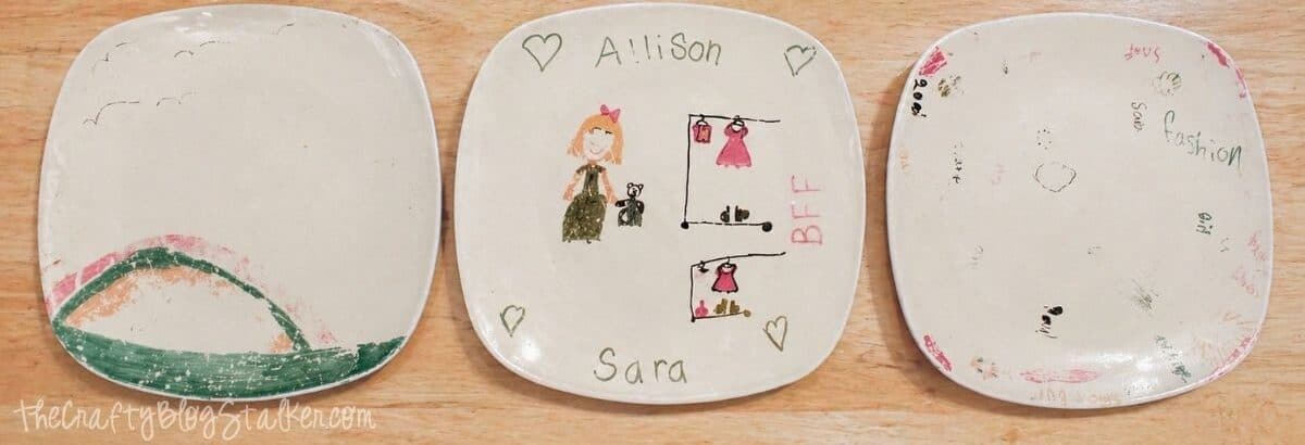 Three ceramic plates after washing, showing faded and worn Sharpie drawings compared to original designs, on a wooden table.