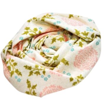 Hand-sewn ruched fabric flower made from floral print material in soft pink, green, and blue tones, rolled and stitched into a rose shape.