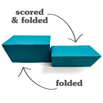 Two pieces of teal paper, one simply folded and the other scored then folded, labeled with arrows to show the difference in fold quality.
