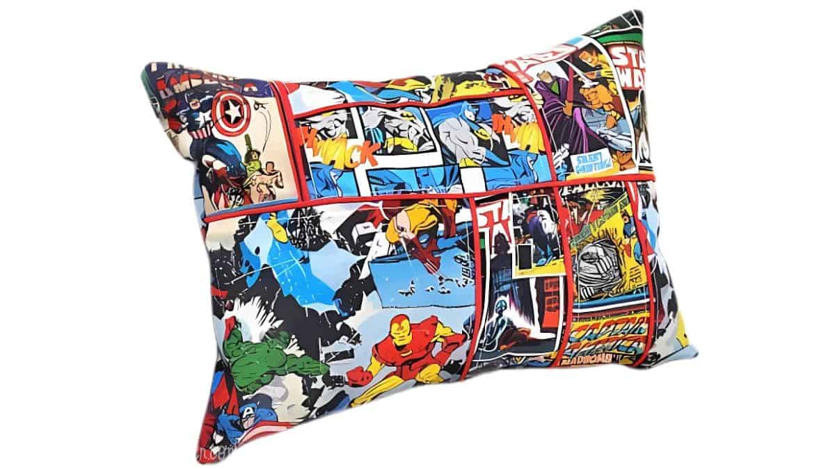 Colorful rectangular pillow with a superhero comic book print featuring characters like Iron Man, Captain America, Hulk, and others in action scenes.