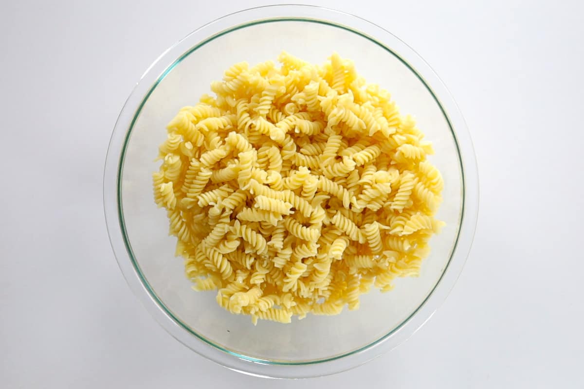 A glass bowl filled with Gluten-Free rotini pasta.