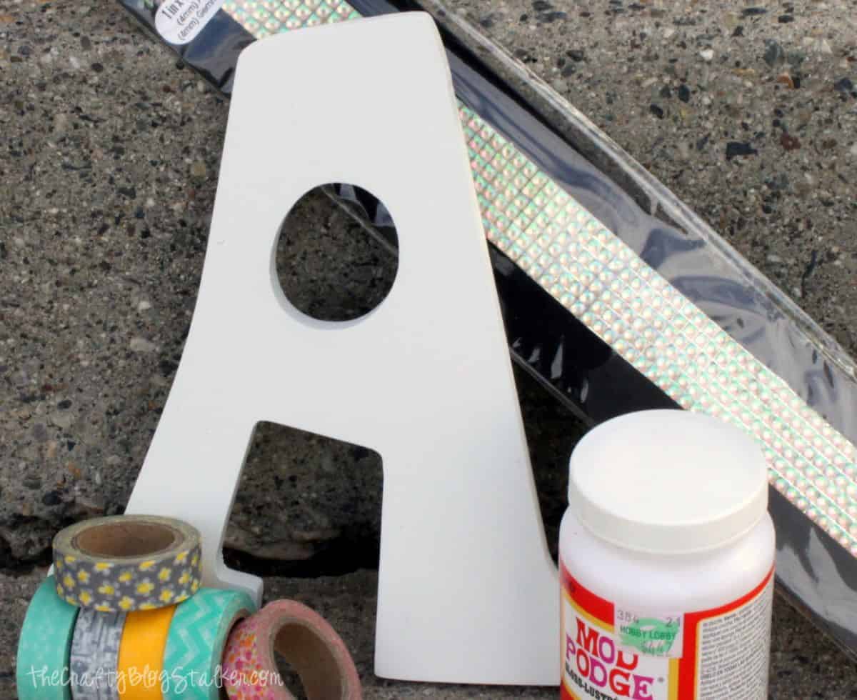 Supplies used: wood monogram letter A, Mod Podge, washi tape, and Gemz.