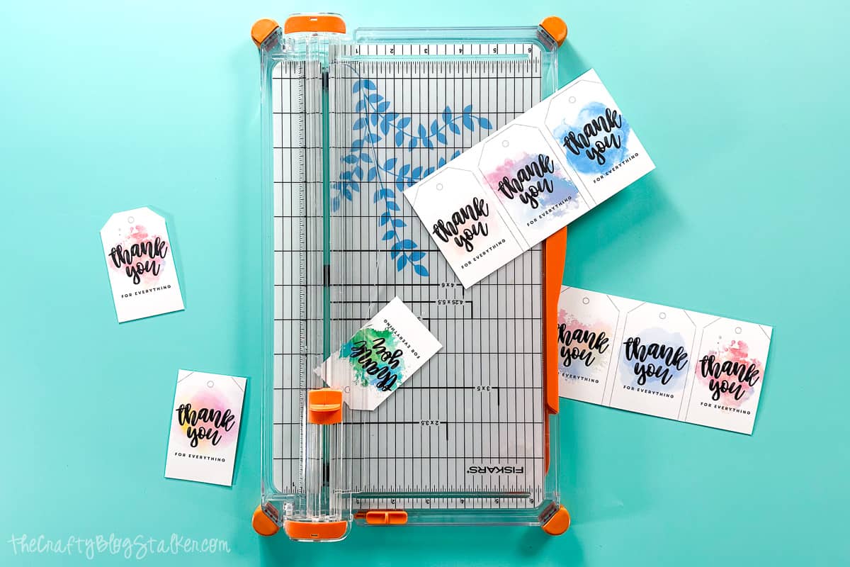 Cutting printable tags apart with a paper trimmer.
