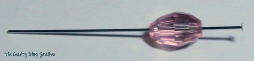 une perle rose sur une épingle à tête