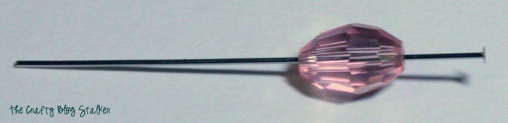 a pink bead on a head pin